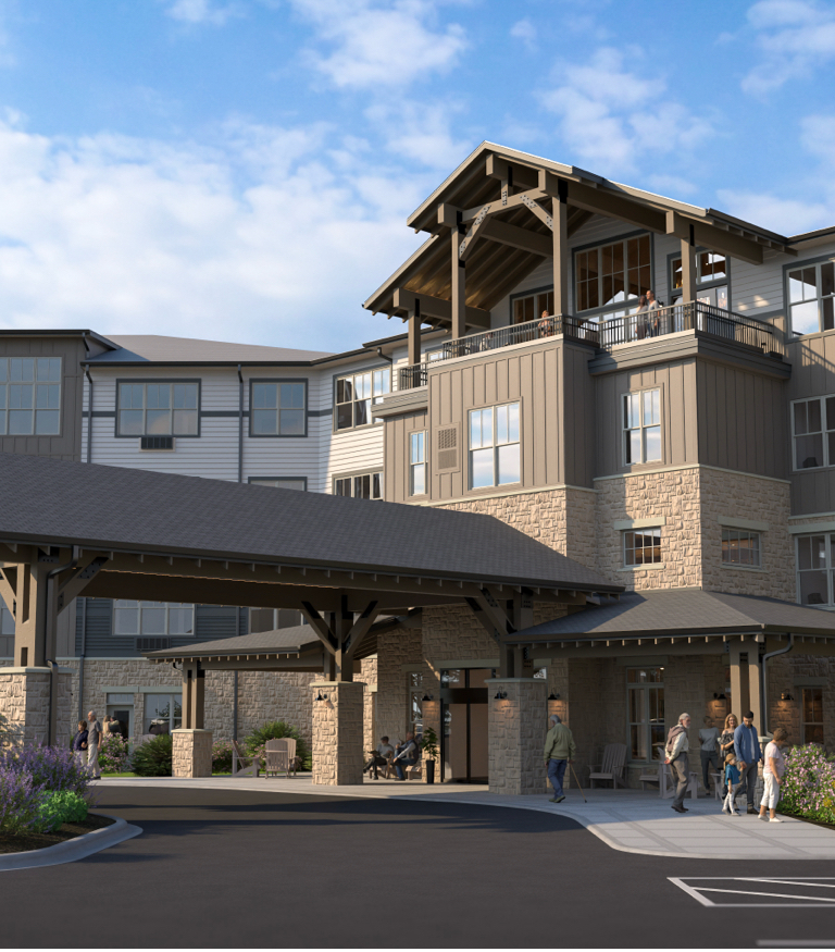Entrance to a modern multi-story building with stone and wood siding, a covered drop-off area, and people walking outside.